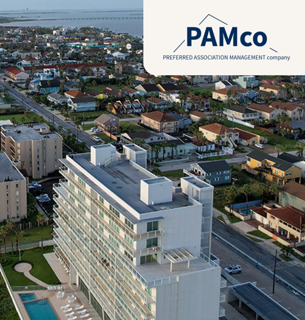 An overhead shot of a highrise condo building near the ocean